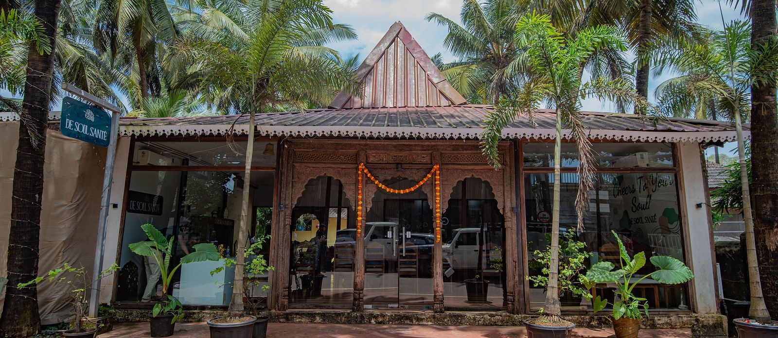 Main entrance with traditional Goan-style architecture surrounded by palm trees at De Soul Santé, Morjim