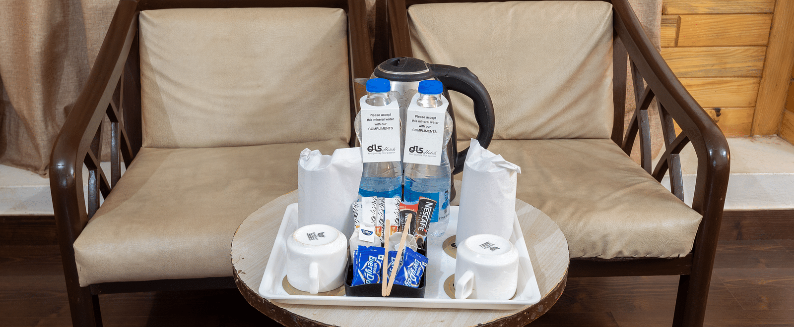 Image of two chairs with tea and coffee essentials kept on the table | DLS Anupam Resort, Dharamshala