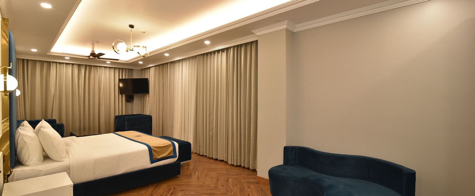 A spacious bedroom with a comfortable bed and large windows offering stunning mountain views. The room features elegant decor and a relaxing atmosphere.