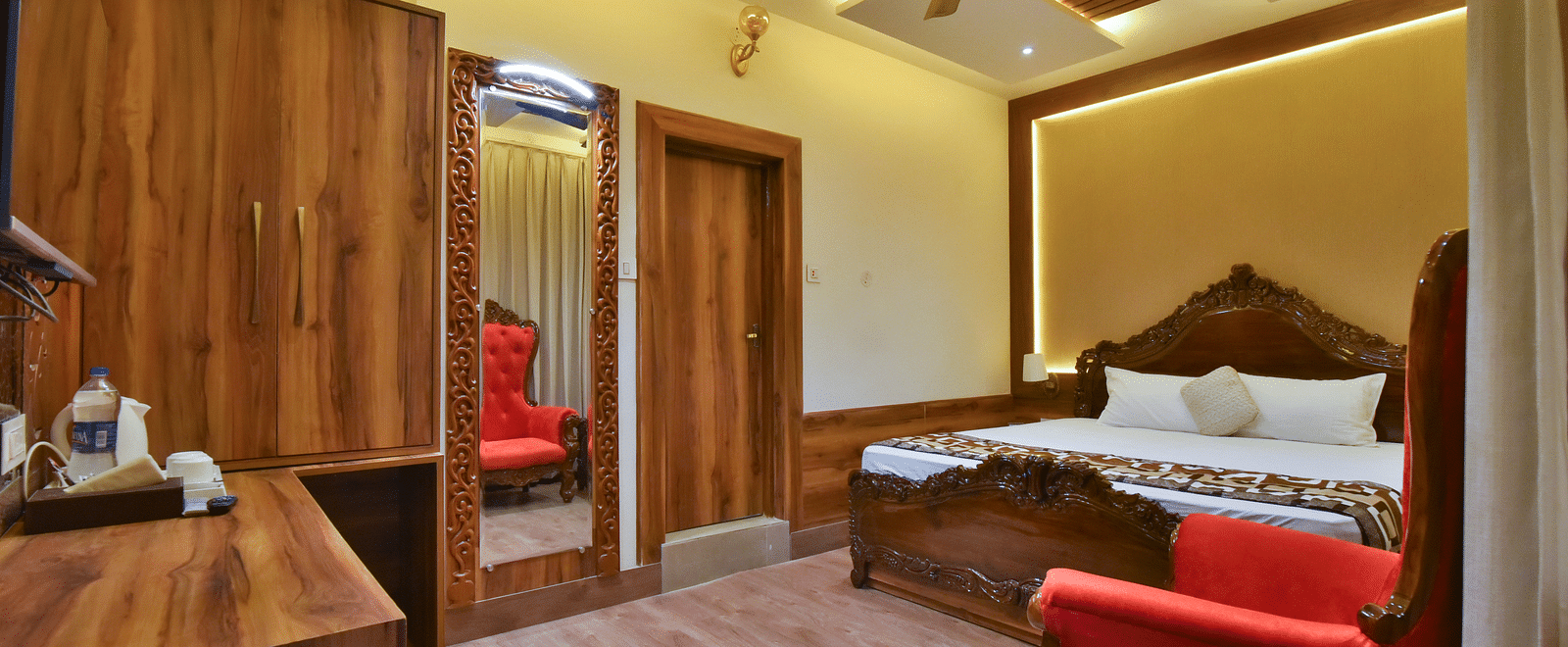 Super Deluxe room at DLS Dalhousie Valley Resort featuring a king size bed, mirror and other amenities. 