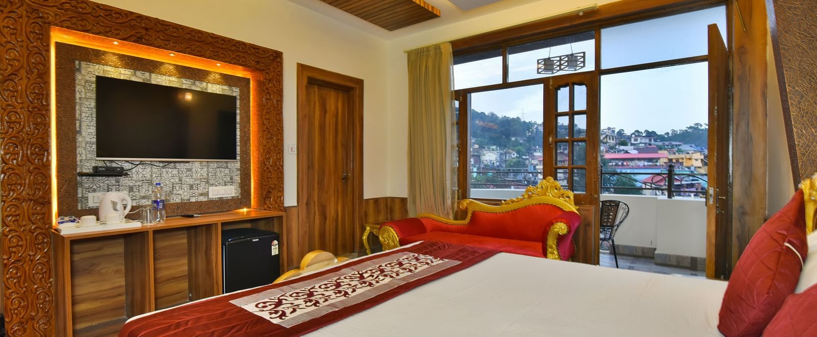 A Luxury Room at DLS Dalhousie  Valley Resort with a premium bed, a sofa, TV and balcony.