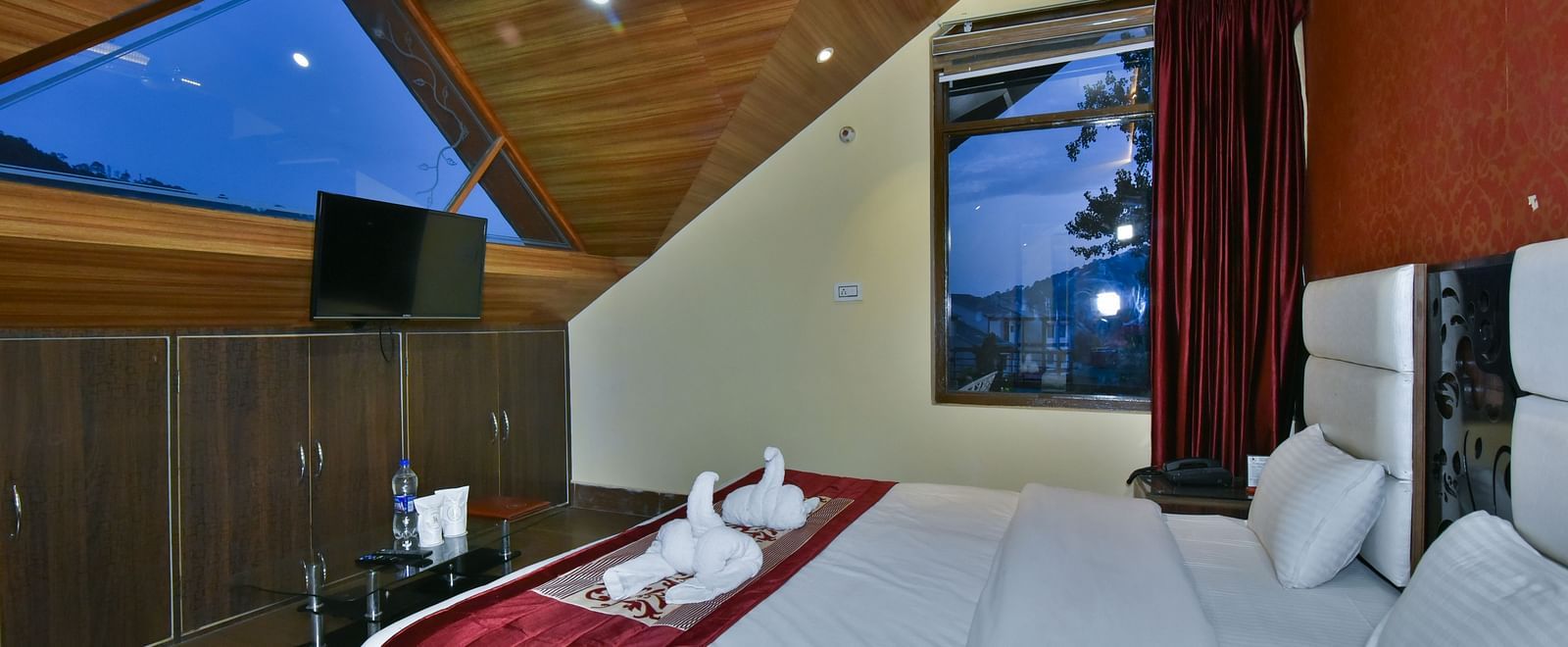 Family Suite at DLS Dalhousie Valley Resort with a king size bed, a table, chairs and a window. 