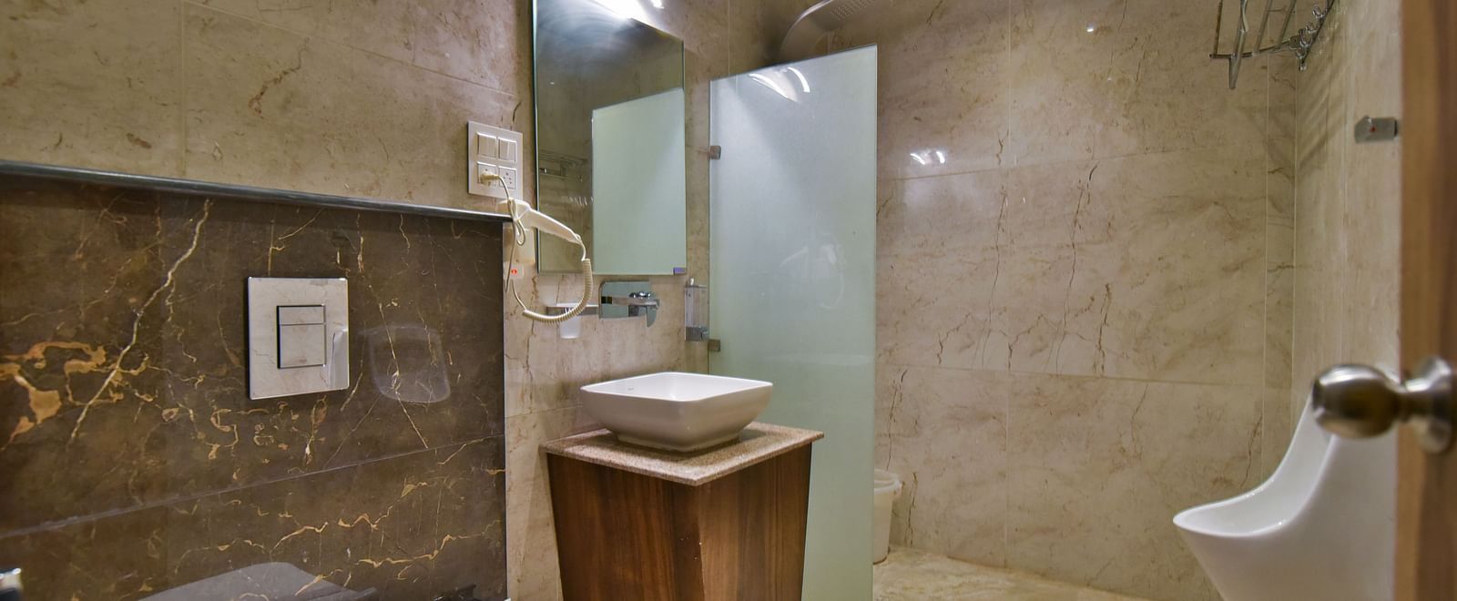 Bathroom of Deluxe Room at DLS Dalhousie Valley Resort with a sink mirror and a toilet.