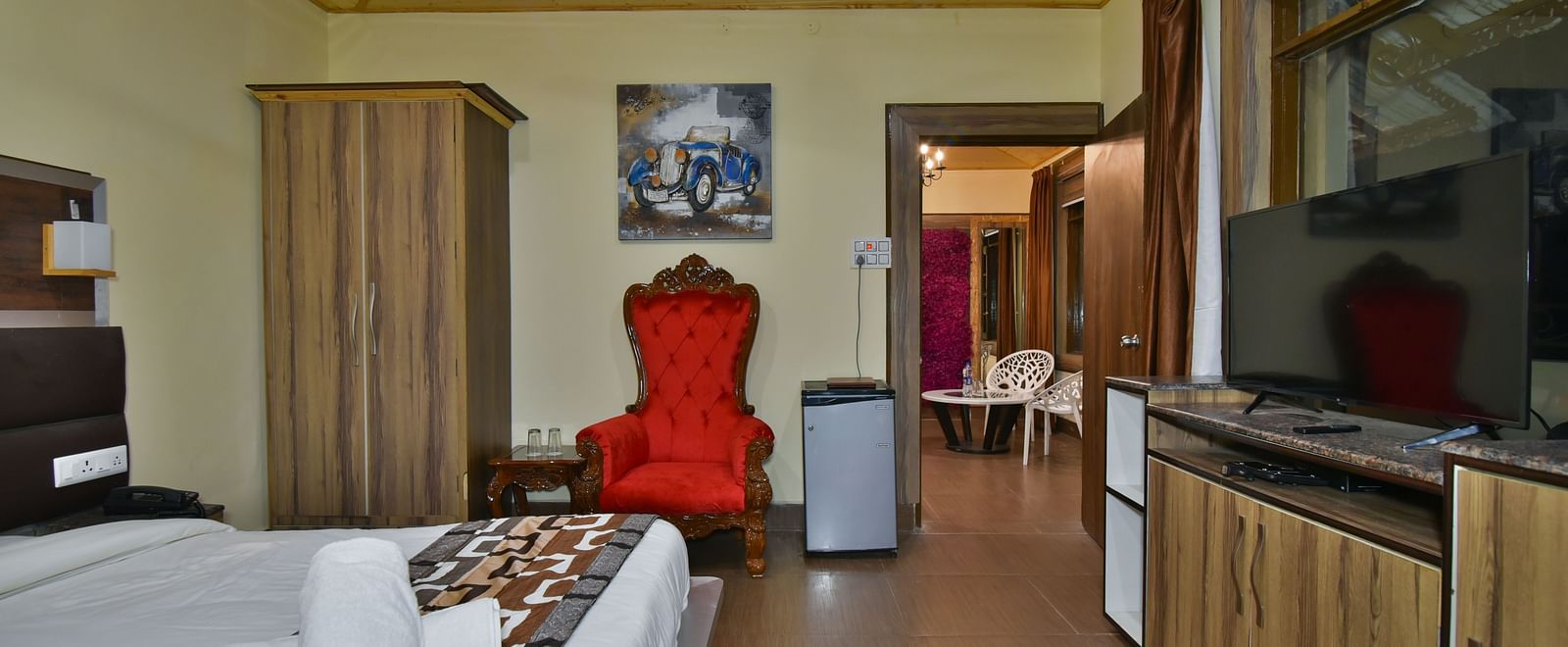 Family Suite at DLS Dalhousie Valley Resort with a king size bed, a table, chair and a door. 