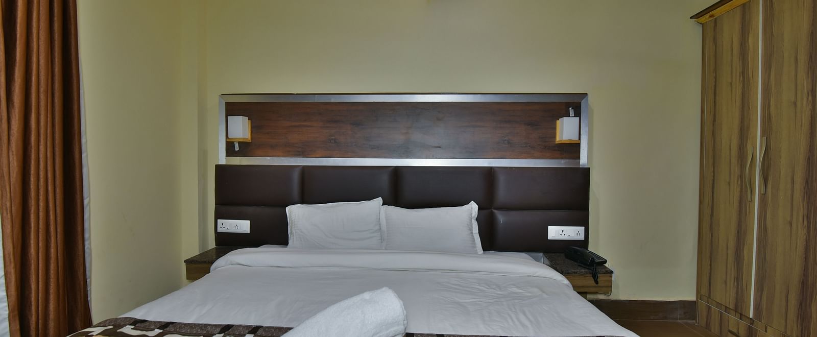 Family Suite at DLS Dalhousie Valley Resort with a king size bed, towels and ambient lighting. 
