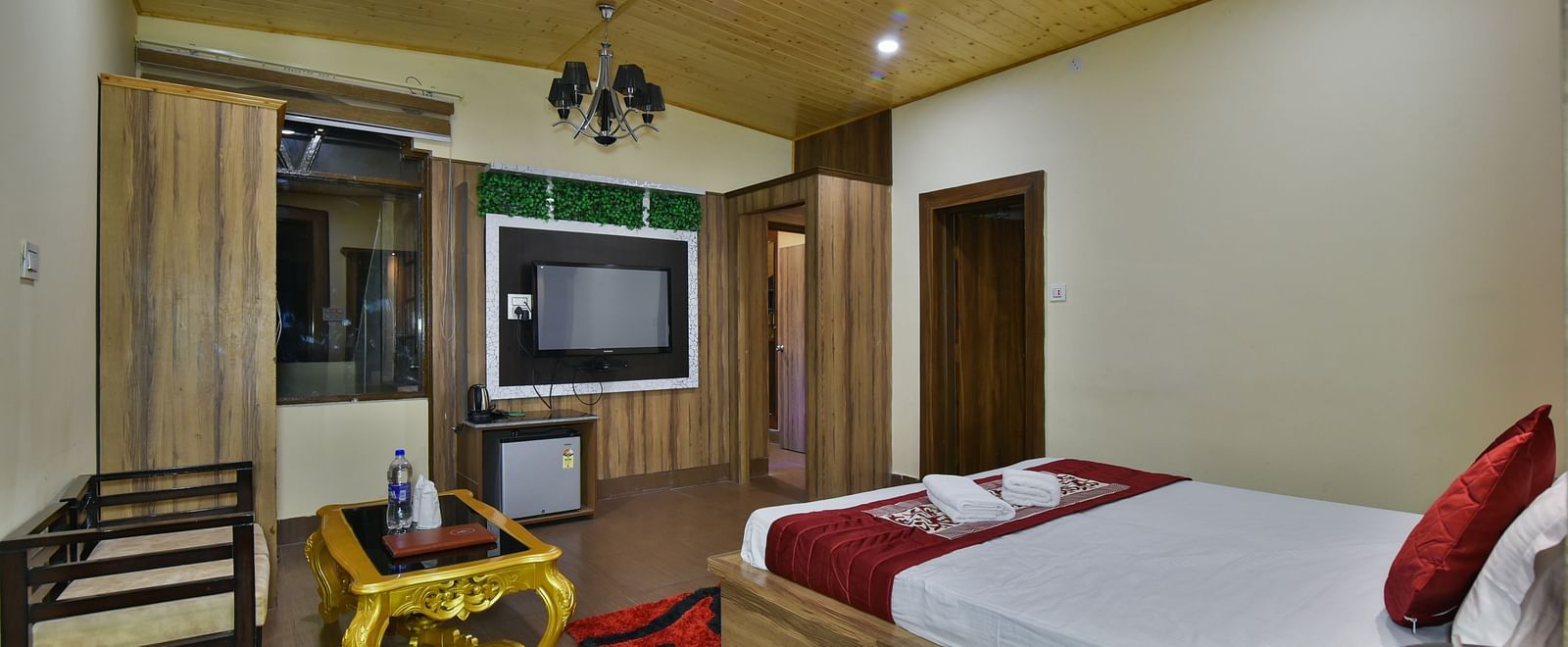 Family Suite at DLS Dalhousie Valley Resort with a king size bed, a table, sofa and a TV 