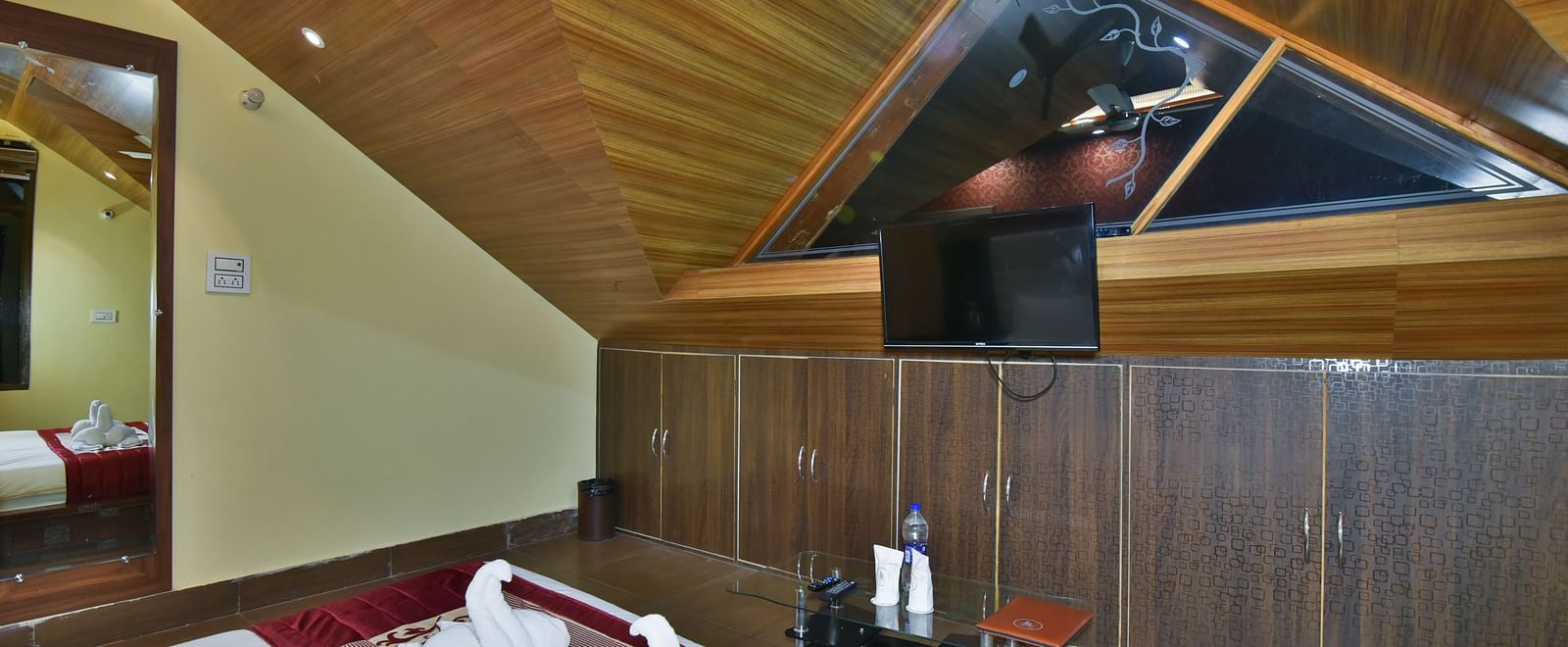 A Deluxe Room at DLS Dalhousie Valley Resort with a  king size bed, TV and a mirror.