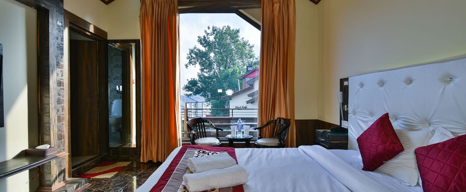 Overview of a Deluxe Room at DLS Dalhousie Valley Resort with a  king size bed and a balcony 