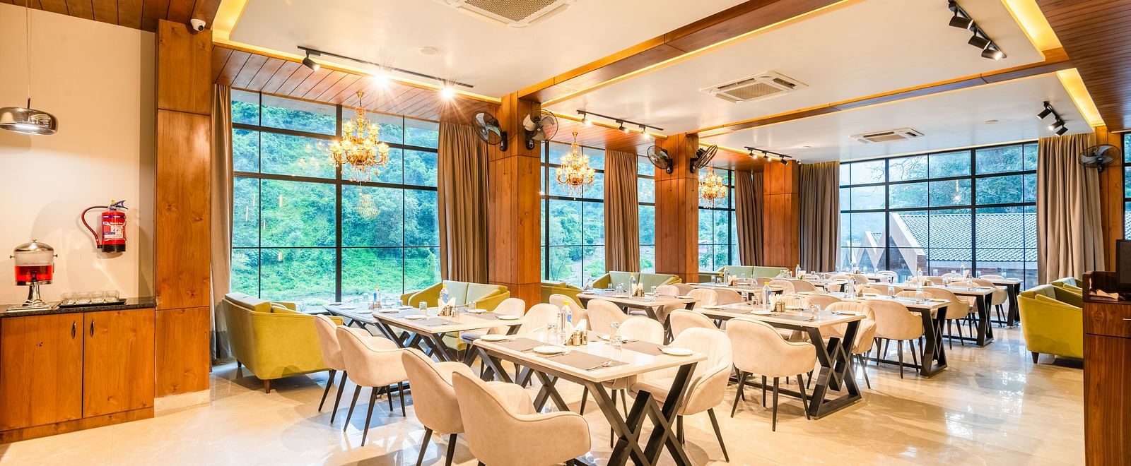 Restaurant at DLS Divine River Resort and Spa  with seating arrangement, large window and ambient lighting. 
