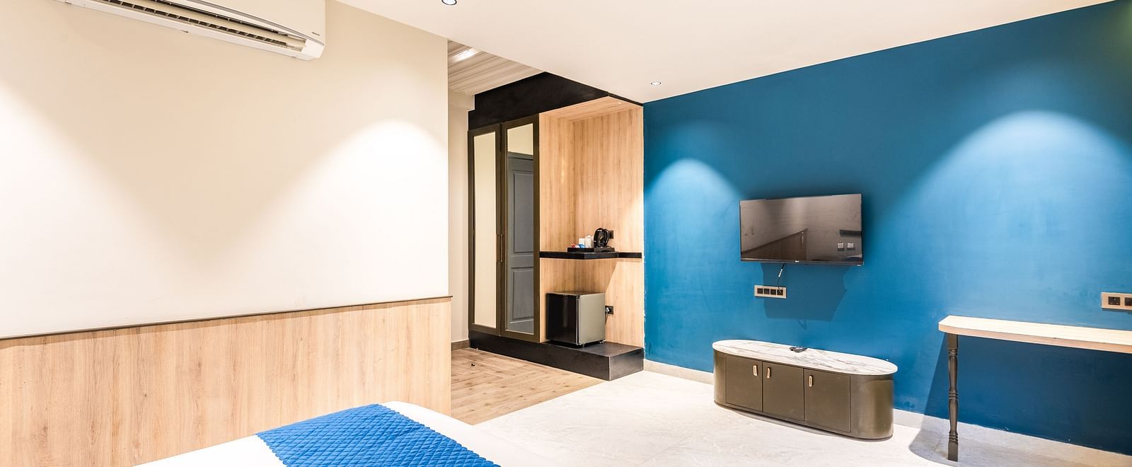 Deluxe Room at DLS Divine River Resort and  Spa featuring a  king bed , side table, TV,  warm lighting and other amenities.