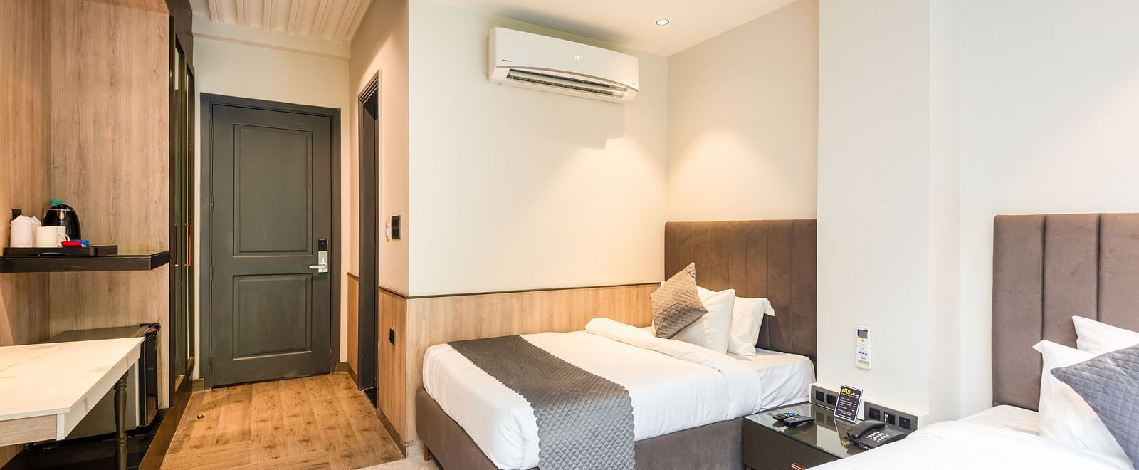 Deluxe Room at DLS Divine River Resort and  Spa featuring a two king bed , side table, warm lighting and other amenities.