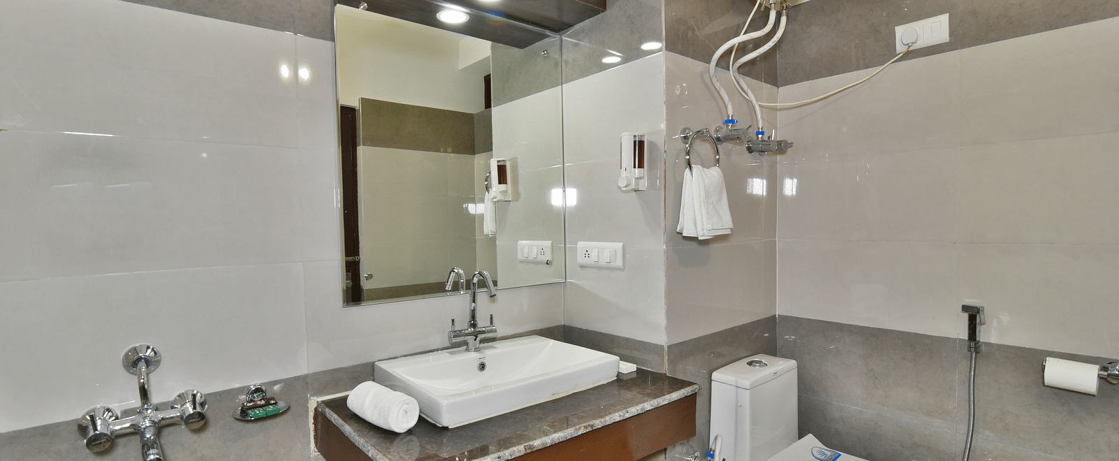 Image of a well equipped washroom featuring a wash basin and a commode | DLS Kapoor Resort Manali