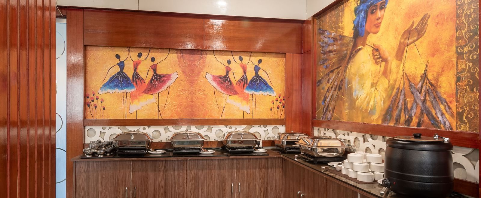Buffet area at DLS Park Grace, Haridwar featuring  various food options, wall art and wooden furniture.
