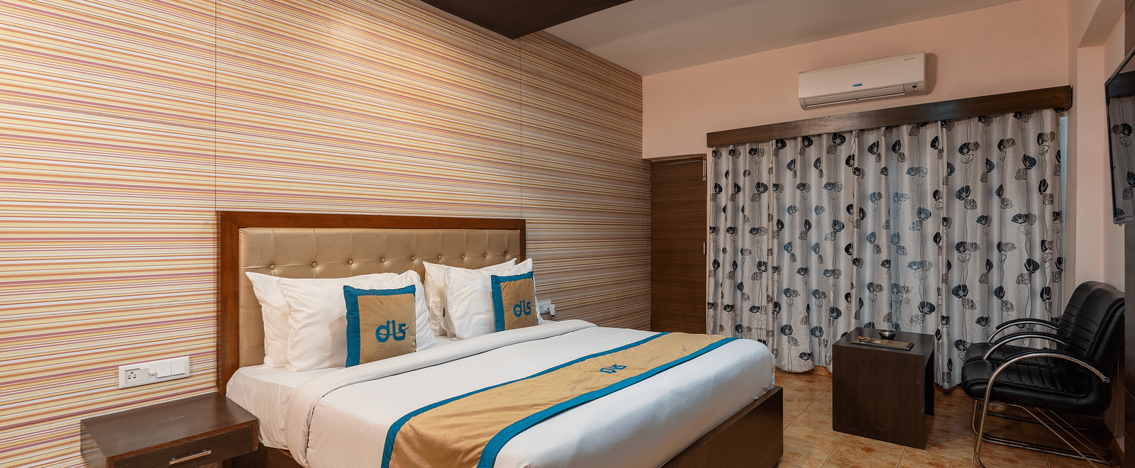 Overview of Deluxe Non view room at DLS Spring Valley resort  Dharamshala featuring a  king bed, table, chairs, AC and a TV