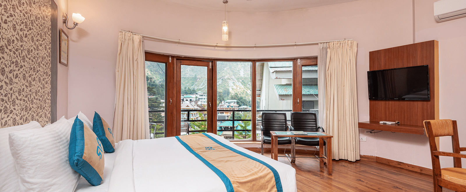 Side view Luxury Cottage at DLS Spring Valley Resort Dharamshala featuring a king size bed, table, TV, and a big balcony
