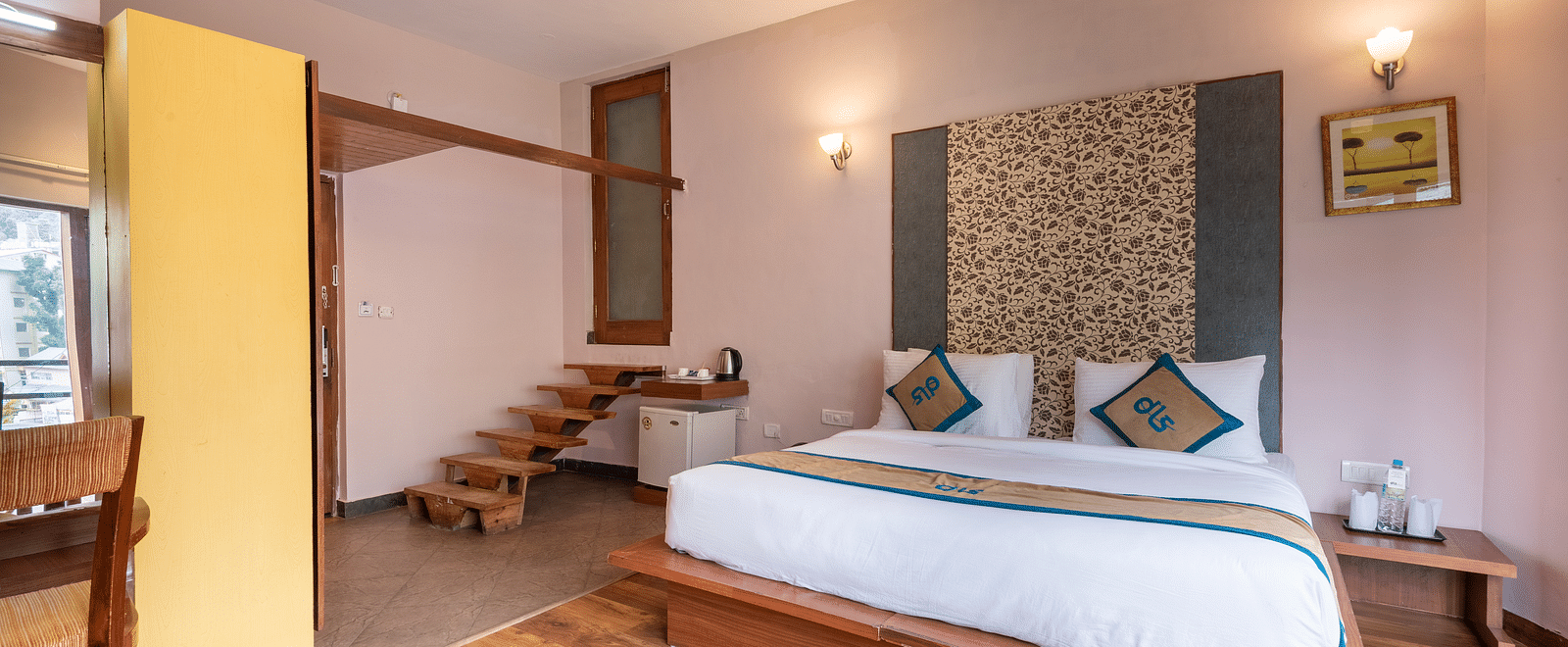 A Luxury Cottage at DLS Spring Valley Resort Dharamshala featuring a king size bed, table and staircase