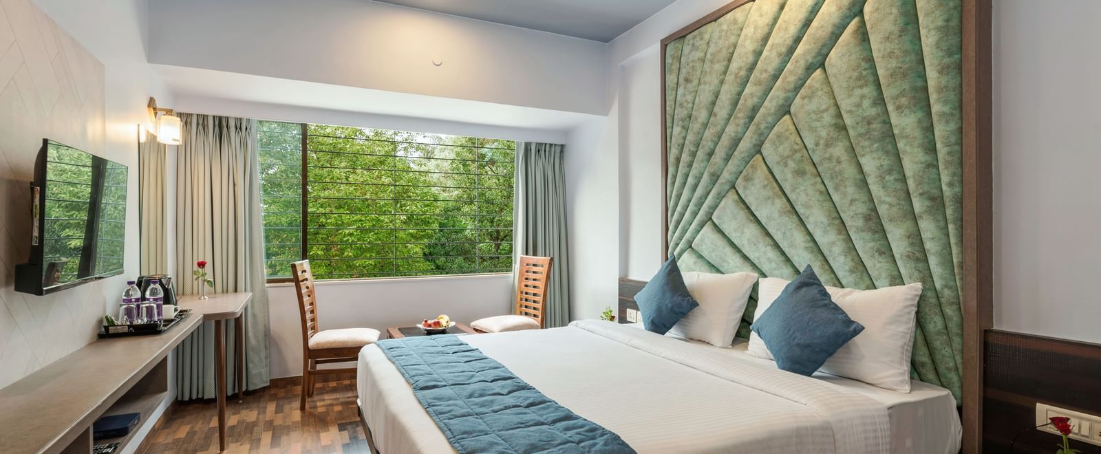 Chic bedroom at Emerald Retreat, Tungarli with a velvet headboard, soothing tones, and garden-facing windows.