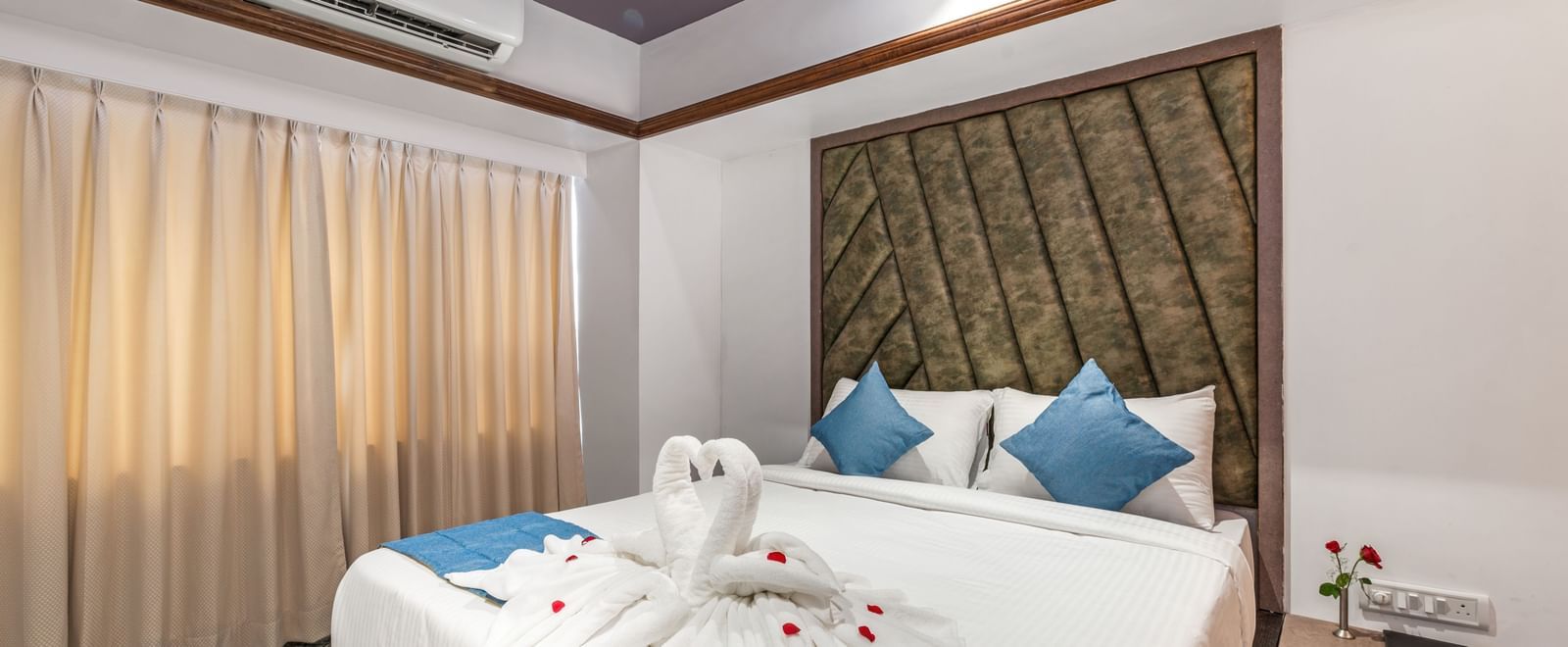 Suite at Emerald Retreat, Tungarli with swan towel decor on the bed, soft ambient lighting, and plush interiors.