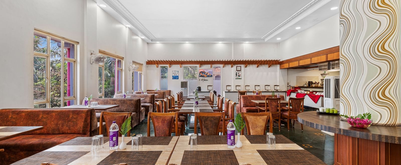 Indoor dining area with wooden furniture and colourful decor, part of The Darbar Restaurant at Mayur Retreat.