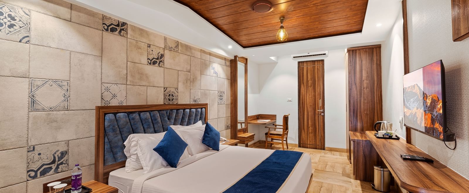 Modern bedroom with a king size bed, wooden ceiling, and stylish lighting at Mayur Retreat.