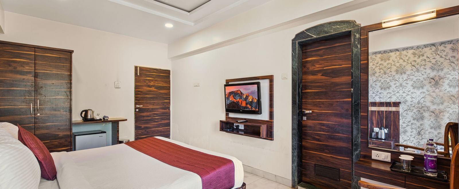 King size bed room at Mayur Retreat with wooden decor and warm ambient lighting.