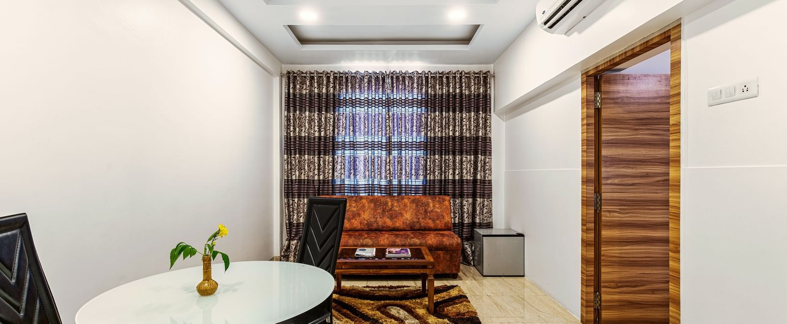 Compact meeting or dining area inside Mayur Retreat, with minimalist decor and seating for four.