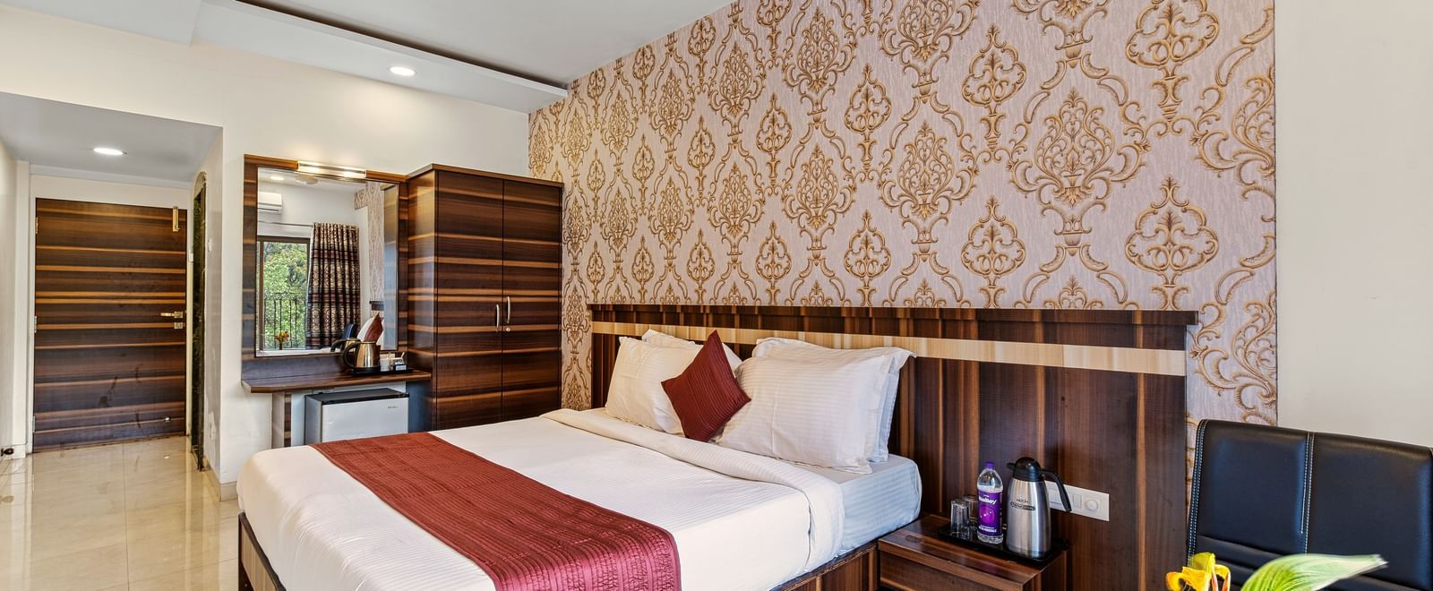 Comfortable bedroom at Mayur Retreat with two single beds, patterned wallpaper, and warm lighting.