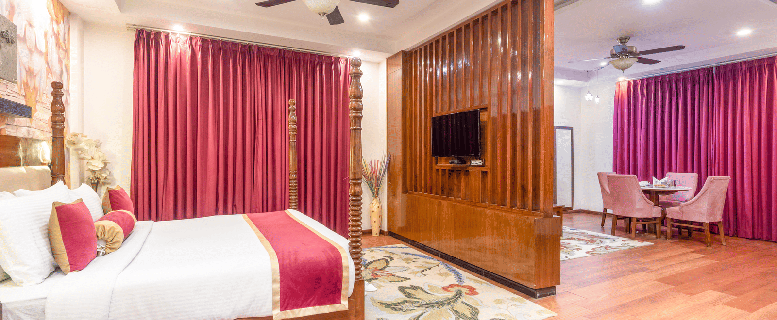 Double bed suite with pink curtains at DLS Hotels On The Ganges.
