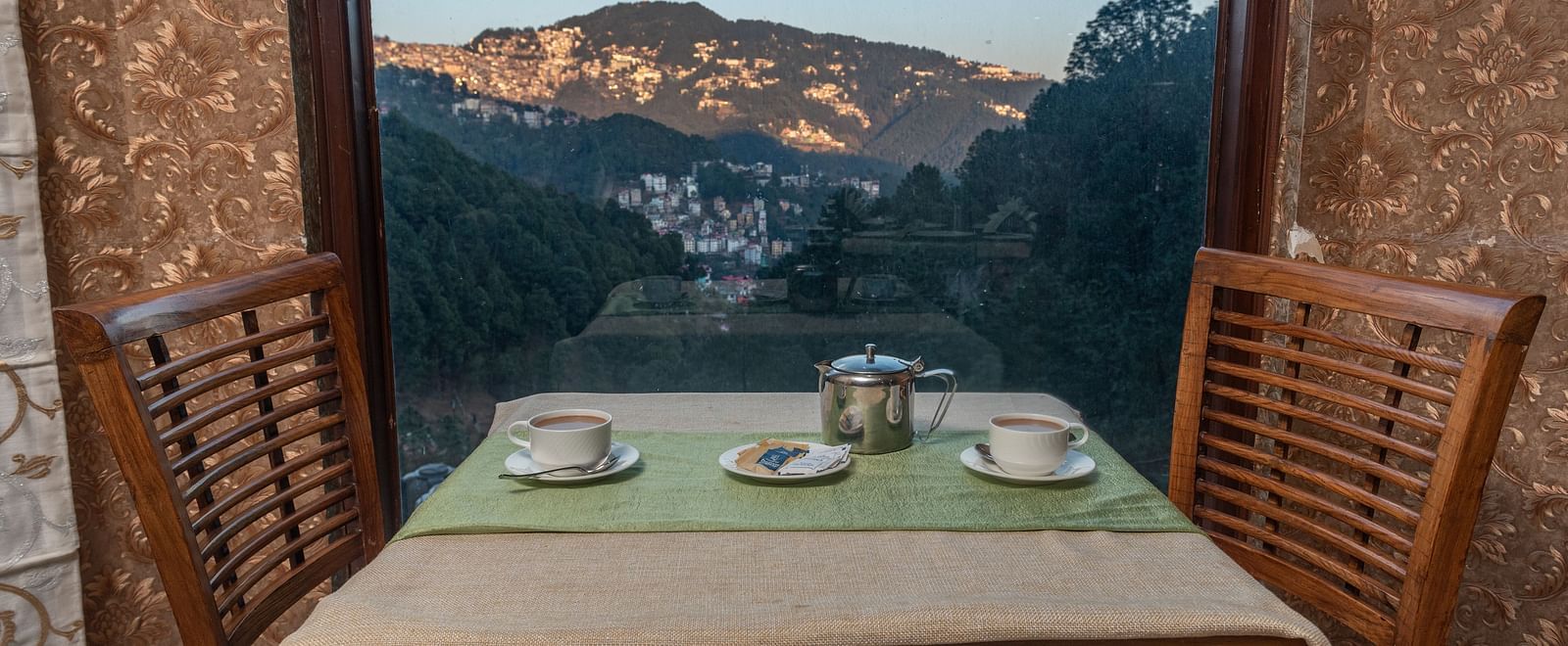 Dining space with a mountain view through the window at DLS Hotels The Rock Castle.