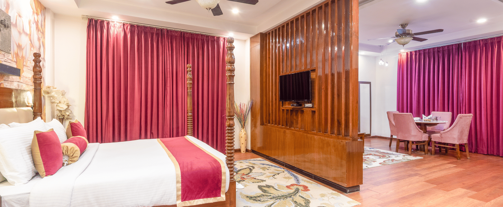 Double bed suite with pink curtains at DLS Hotels On The Ganges.