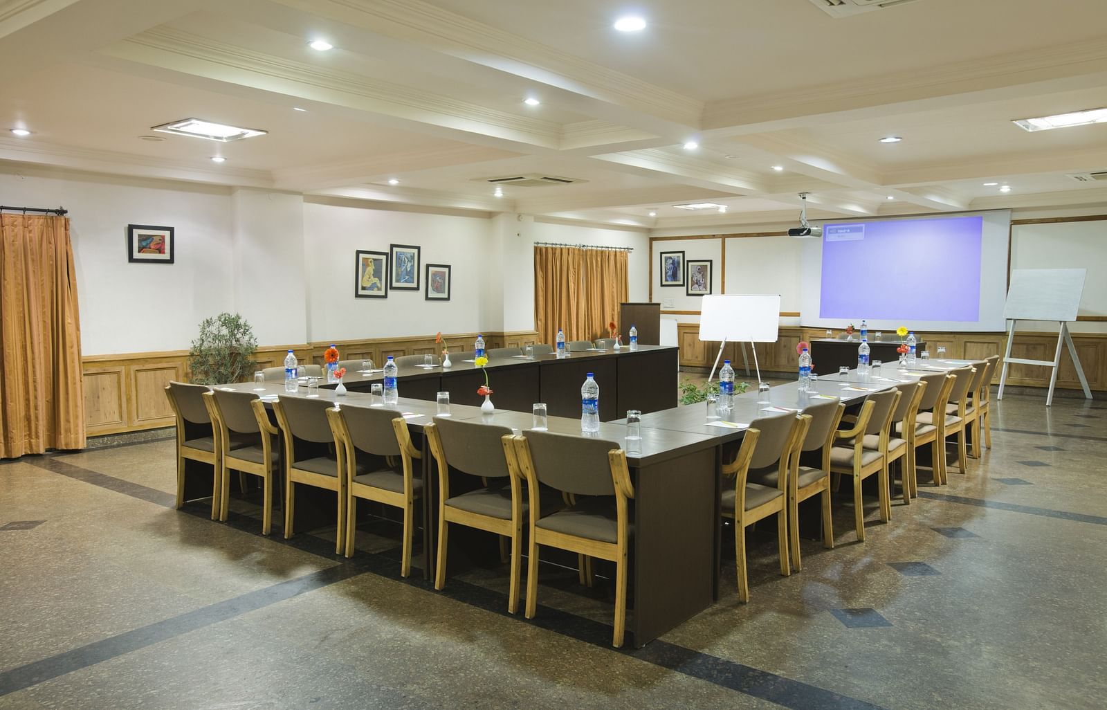 a corner view of a conference room with a U-shaped seating arrangement 
