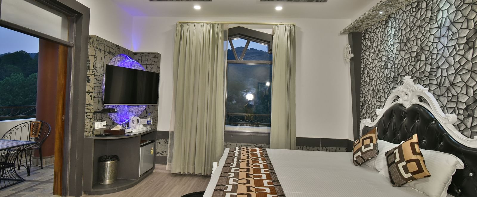 A Luxury Room at DLS Dalhousie  Valley Resort with a premium bed, a sofa, TV and balcony.