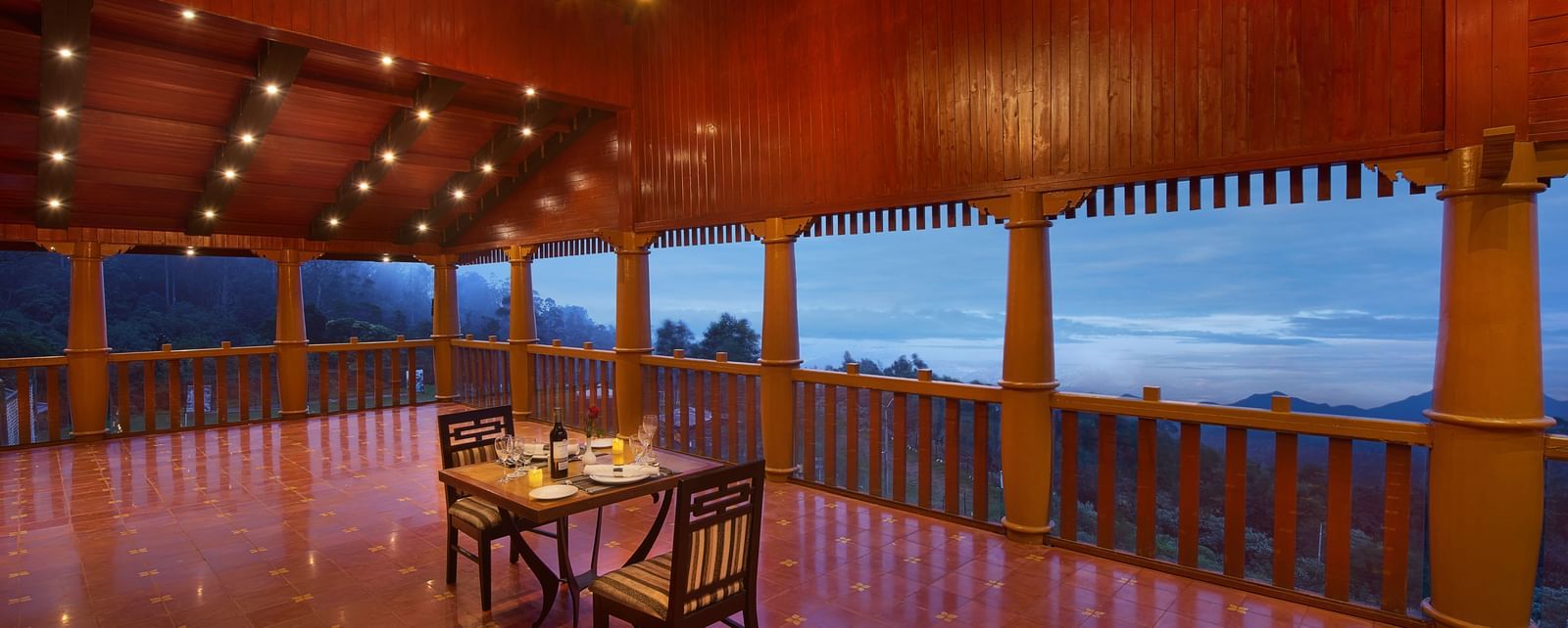 A dining arrangement overlooking the Nilgiri mountains at dusk at Accord Highland Ooty
