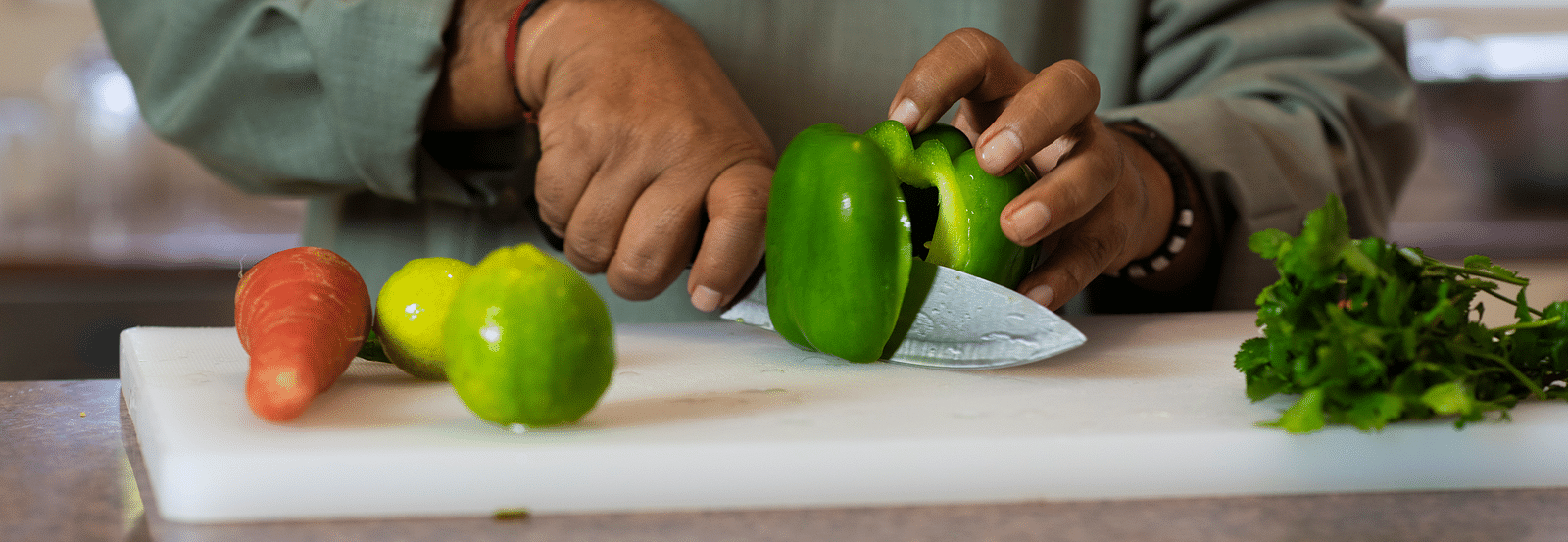 Image of a chef cutting vegetables on a chopping board.