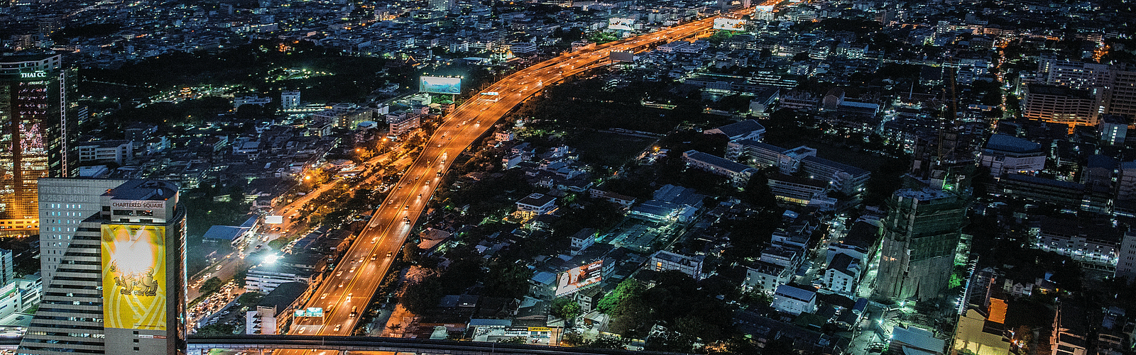 An aerial view of Bangkok during the night with roads and buildings in view.