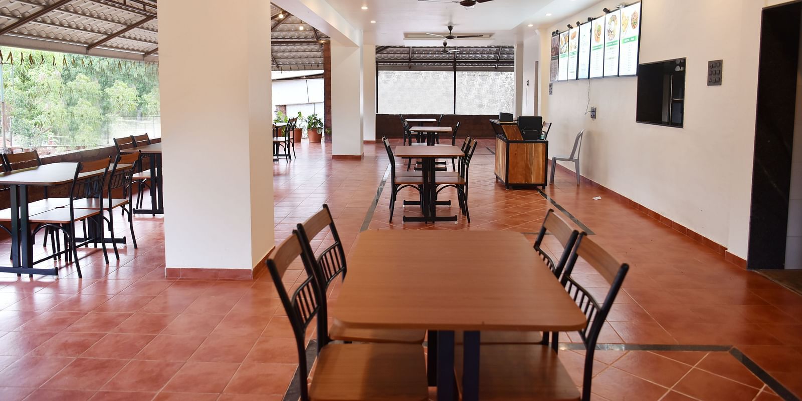 A view of the dining area at Riverside Inn, featuring neatly arranged tables and chairs with ample space around each pair.