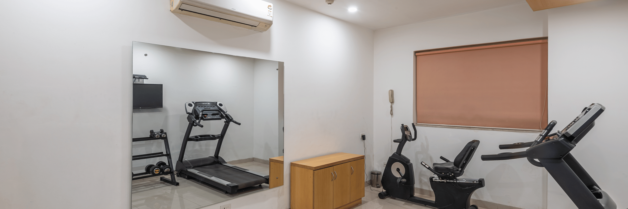 Well-equipped fitness room at Mango Grove featuring treadmills and exercise machines.