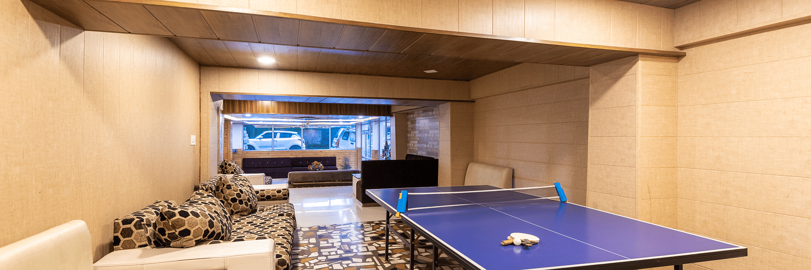 Image of a table tennis zone kept in the lobby with a white couch in the side | DLS Anupam Resort, Dharamshala