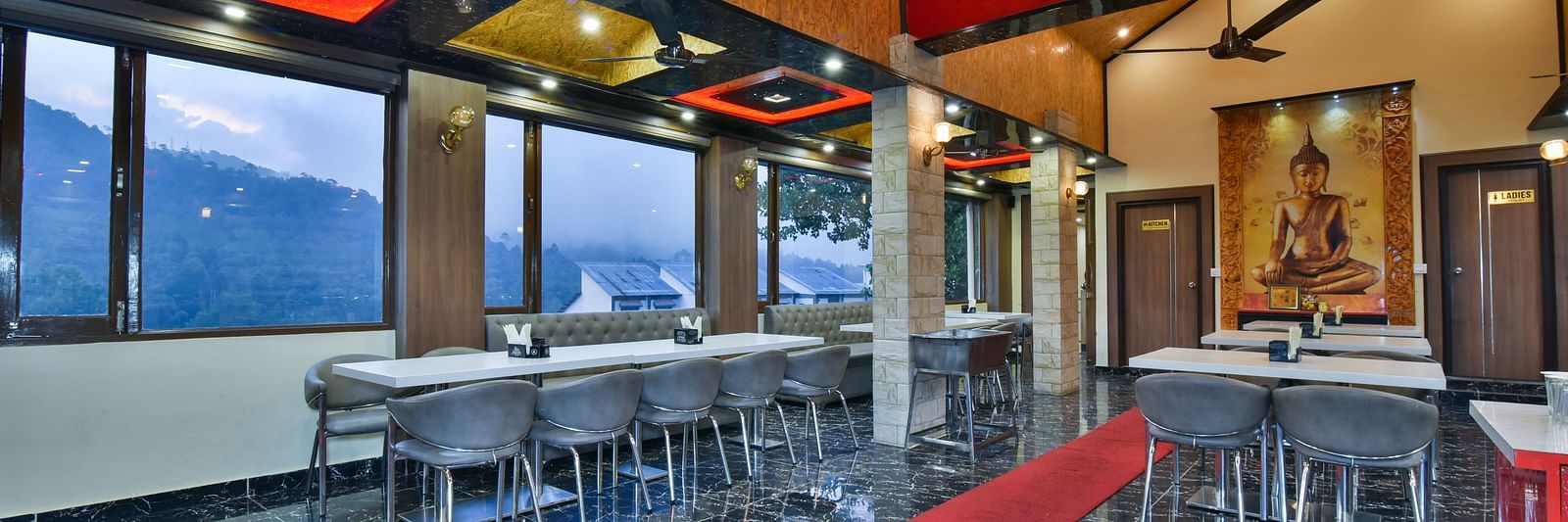 Restaurant at DLS Dalhousie Valley Resort with chairs, tables and serene views