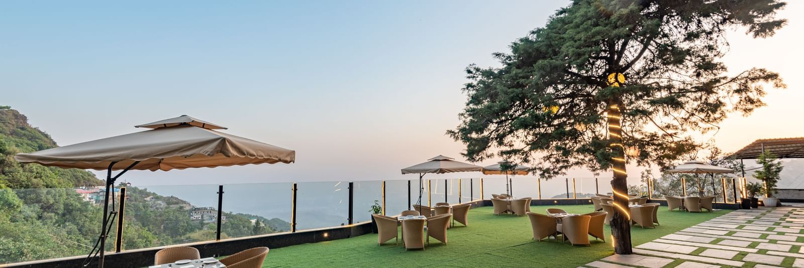 Comfortable seating in the lawn surrounded by hills at dusk at DLS Highland Resort and Spa, Mussoorie.