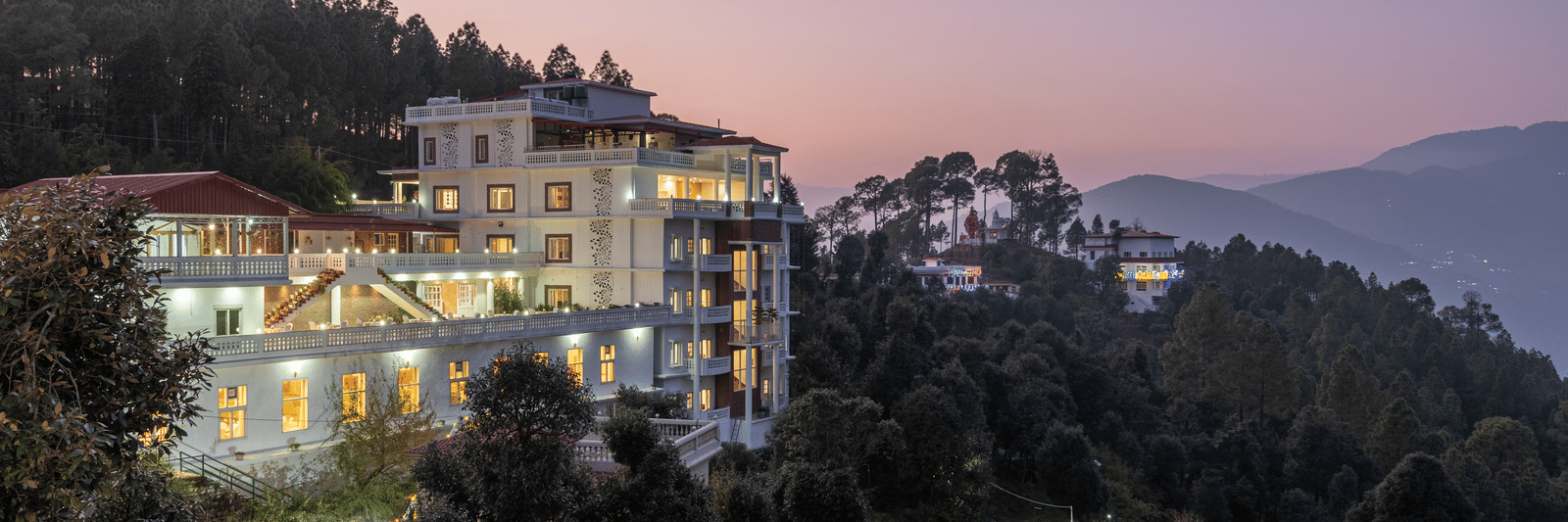 A panoramic view of the DLS Tehri Club Resort at sunset, nestled amidst the scenic hills.
