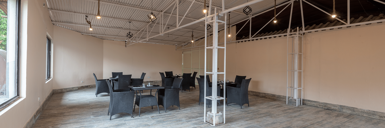 Shot of an empty conference hall with few chairs and tables kept around  | DLS The Pearl