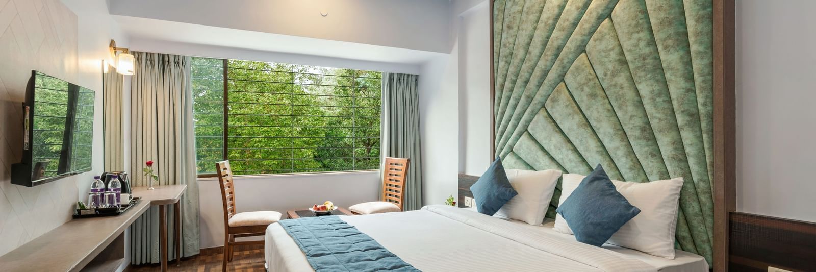 Chic bedroom at Emerald Retreat, Tungarli with a velvet headboard, soothing tones, and garden-facing windows.