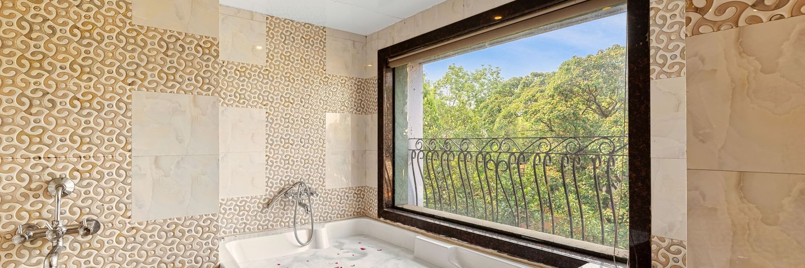 Luxurious bathroom featuring a large bathtub by a window with scenic outdoor views at Mayur Retreat.