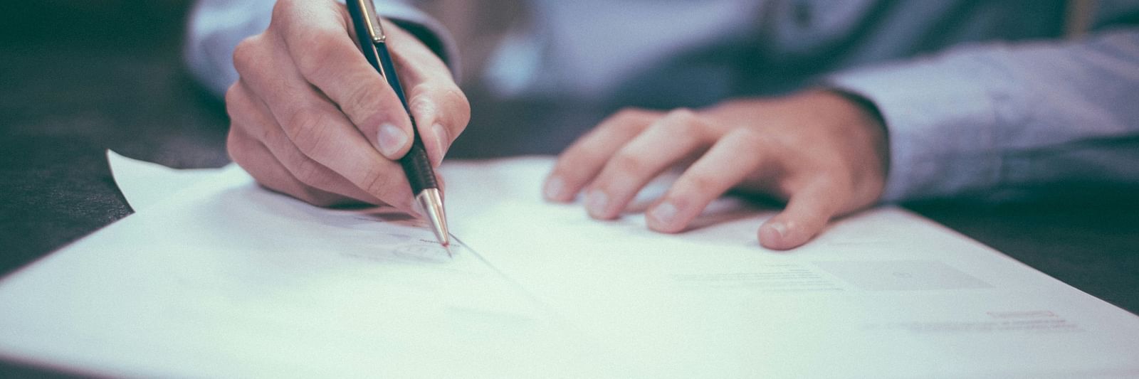 A person writing on a sheet of paper