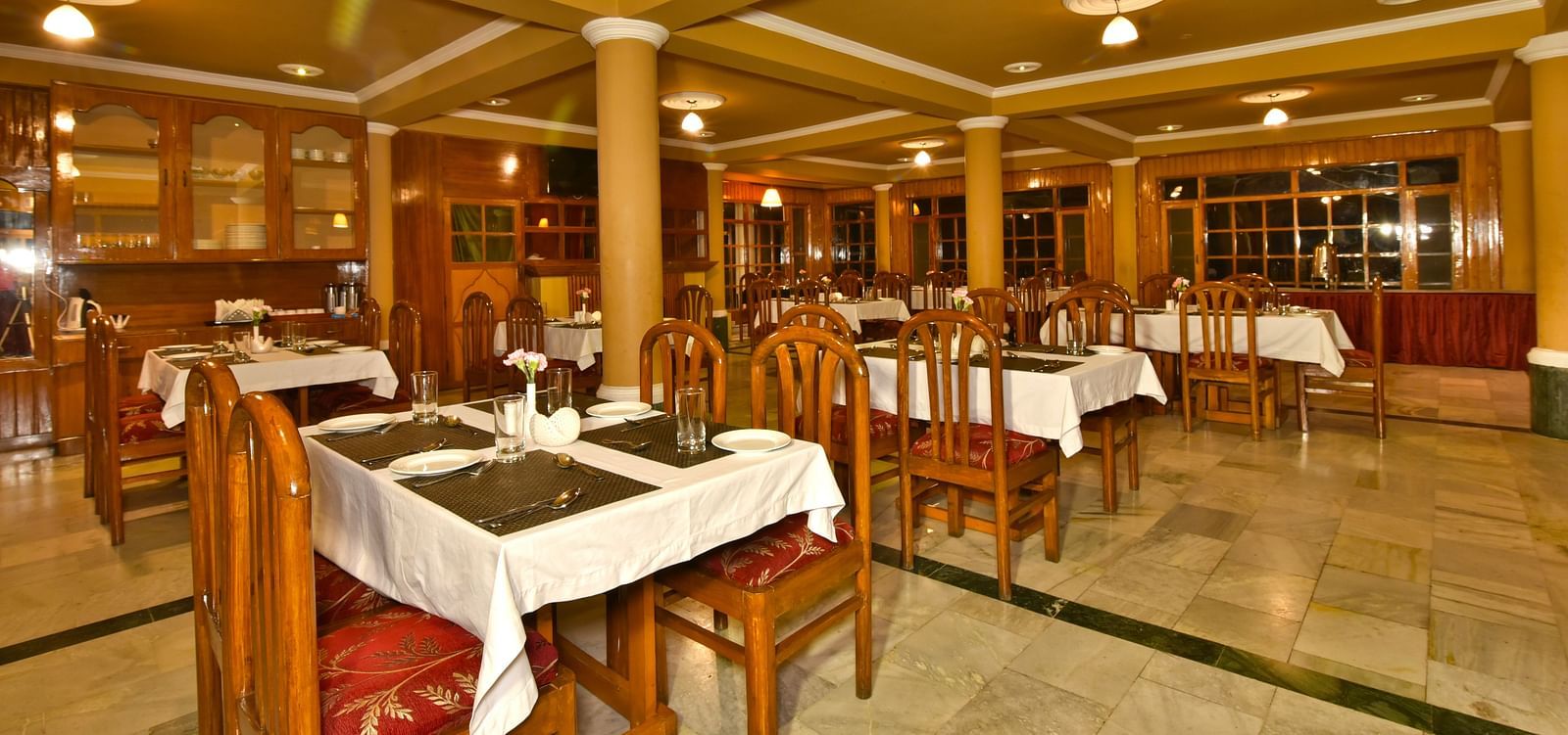 A cosy dining space with tables and chairs at DLS Hillcrest Resort, Shimla.