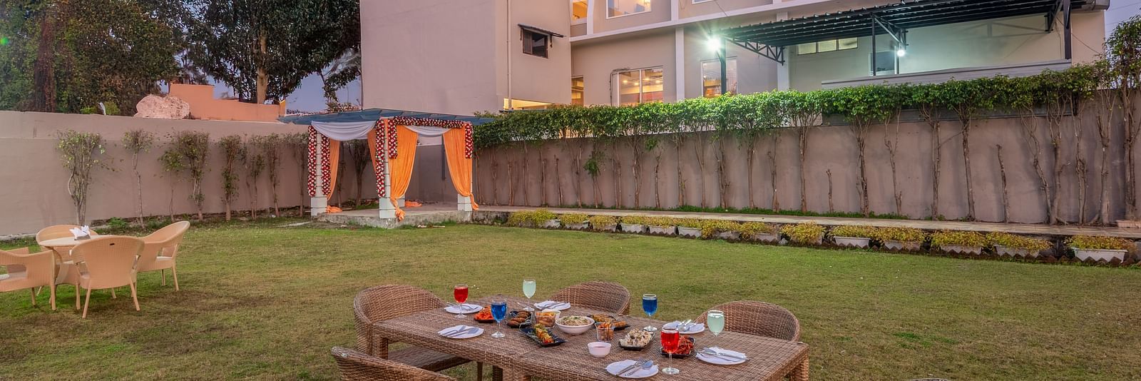 Lawn area at DLS Park Grace, Haridwar featuring multi storey building, seating area and beautiful green lawn.