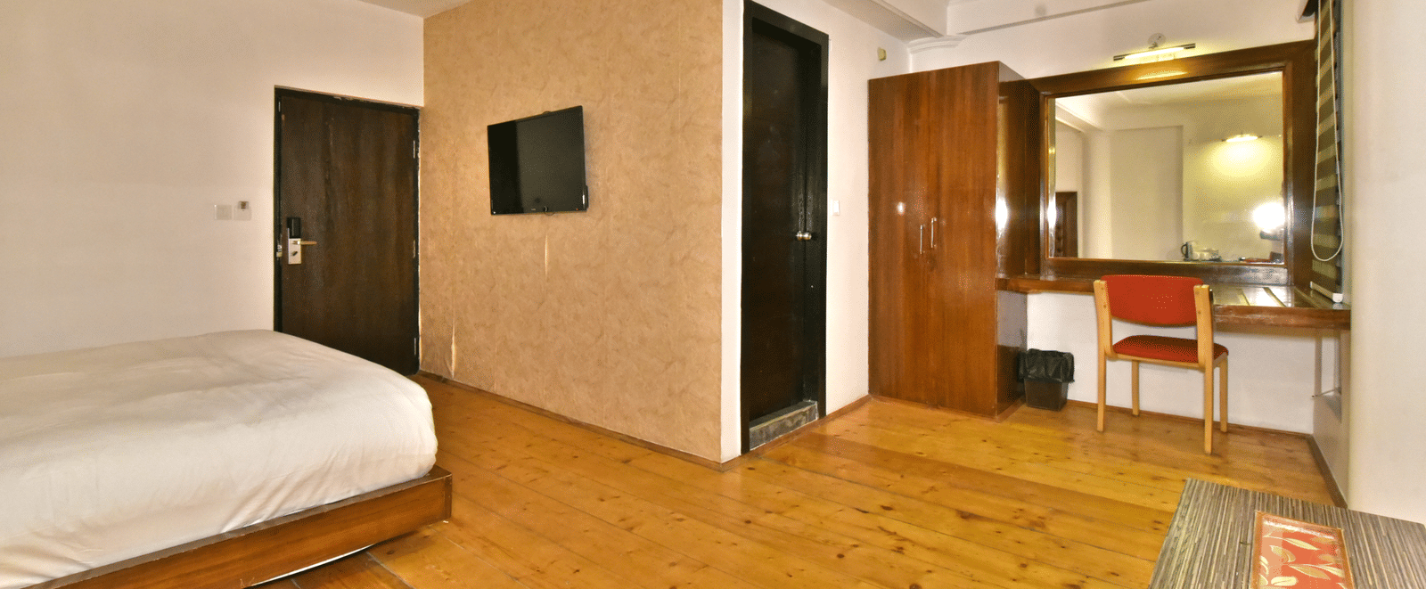 Living area of the suite with wooden-finished flooring at DLS Hillcrest Resort, Shimla.