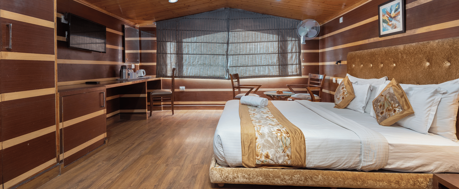 A bedroom with a sheer curtain covered and a television
