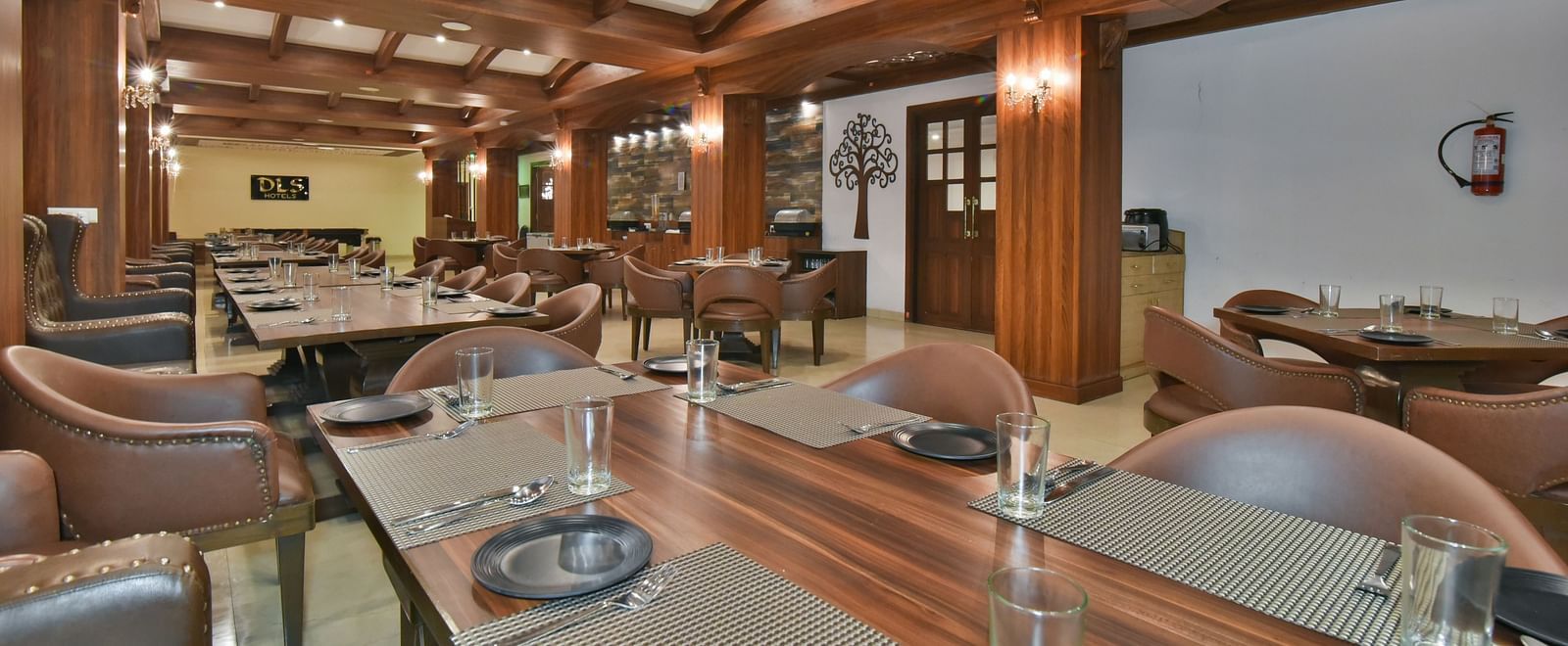 Dining seating with comfortable chairs around table at Ruttba at DLS Highland Resort and Spa, Mussoorie.